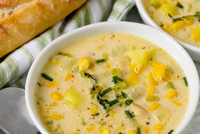 Corn soup served in a bowl with a bread on the side