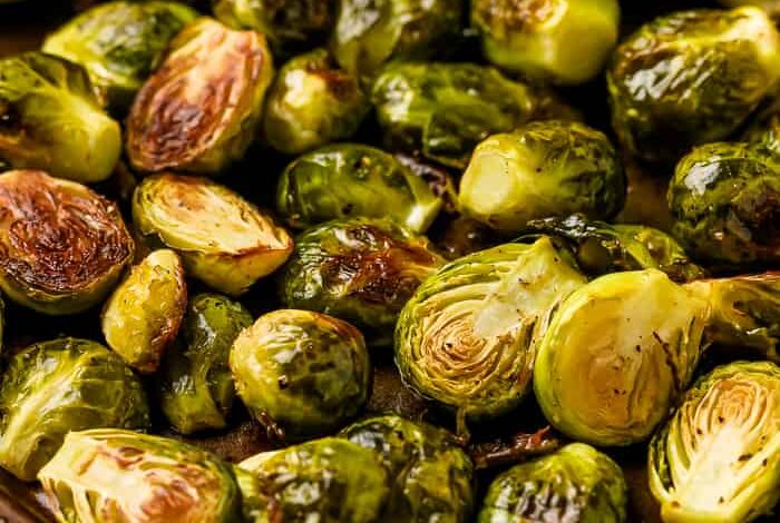 Baked, halved brussel sprouts, oiled and seasoned with pepper in a baking tray