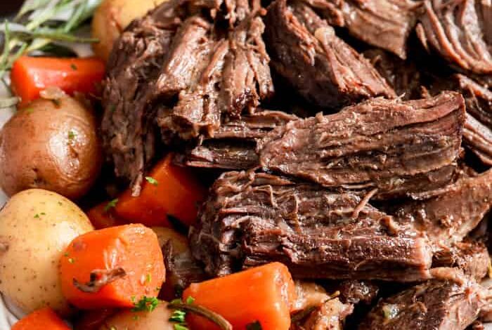 Instant Pot Pot Roast on a plate with veggies and rosemary