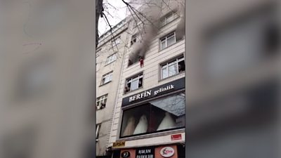 Child hanging from apartment window