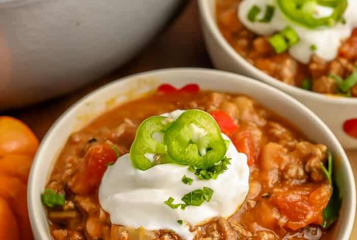 Pumpkin Chili in white bowls with sour cream