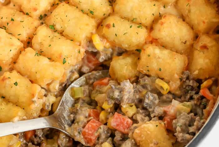 serving spoon scooping classic tater tot casserole