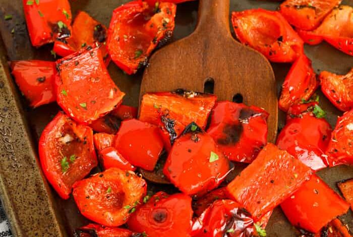 Roasted Red Peppers cooked on a baking sheet with a spoon