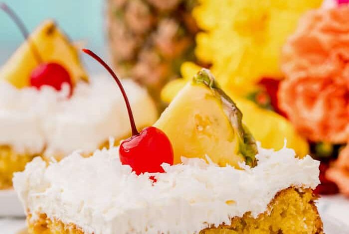 plated Pina Colada Cake with a cherry and pineapple on top