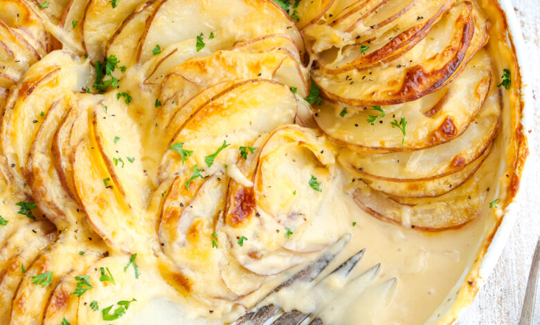 potatoes au gratin in a baking dish with a fork