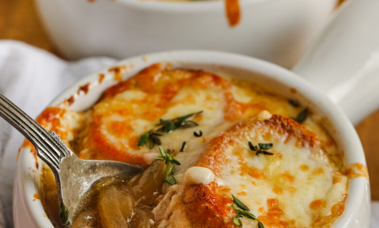 cups of Homemade French Onion Soup with a spoon in one