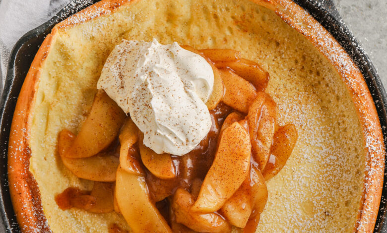 Apple Dutch Baby in a pan with whipped cream