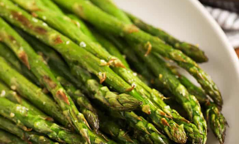a plate of roasted asparagus with salt and pepper