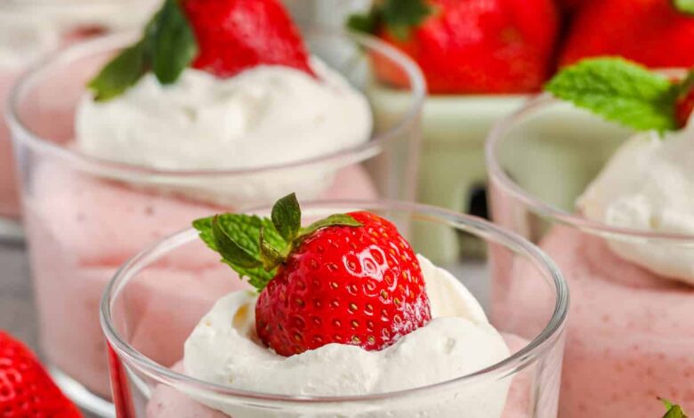 Homemade Strawberry Mousse in cups with whipped cream and extra strawberries