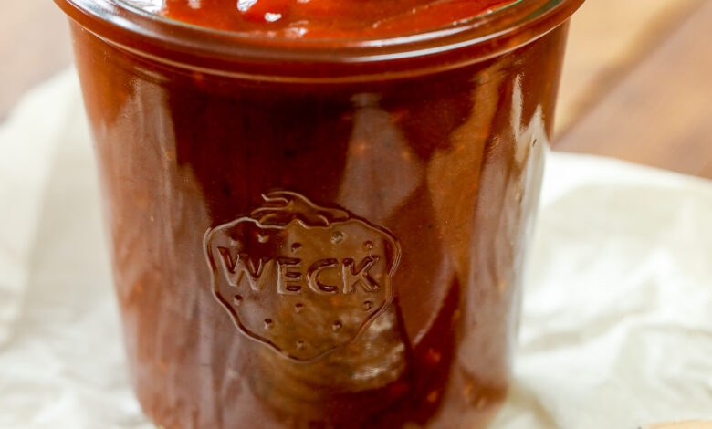 a jar of homemade bbq sauce with a brush