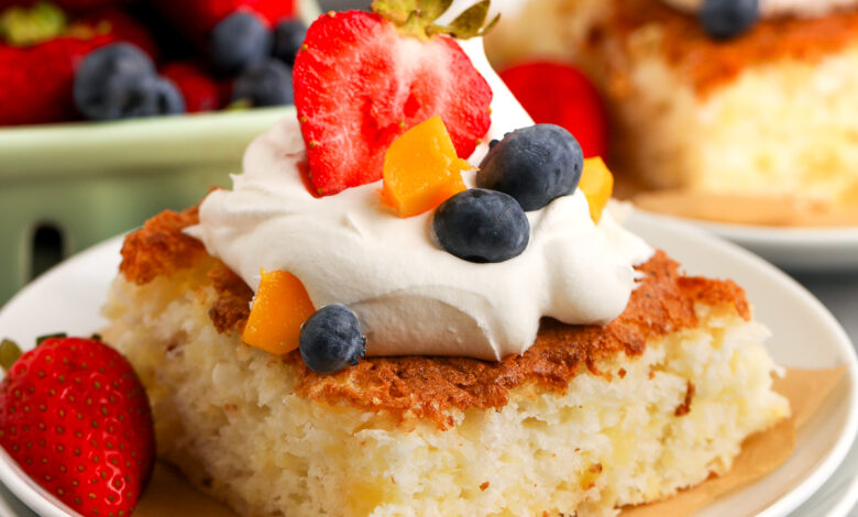 a slice of pineapple angel food cake with whipped topping on a plate