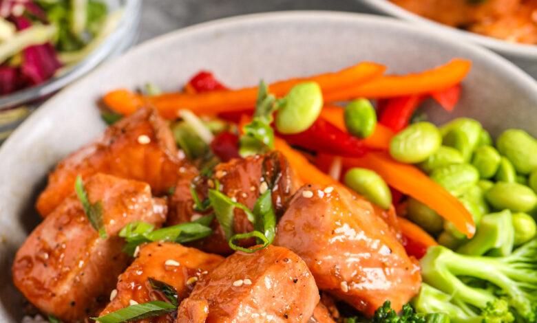 a salmon bowl with fresh vegetables and green onions