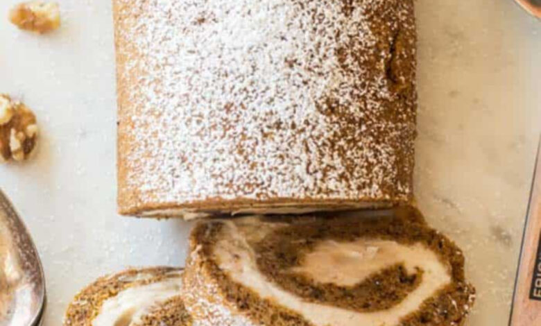 pumpkin roll recipe sliced into three slices with the remaining roll on the board