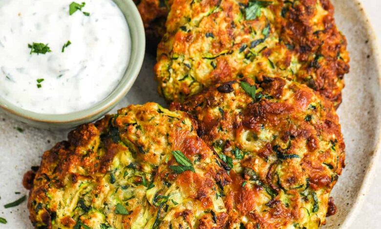 zucchini fritter patties on a plate with ranch