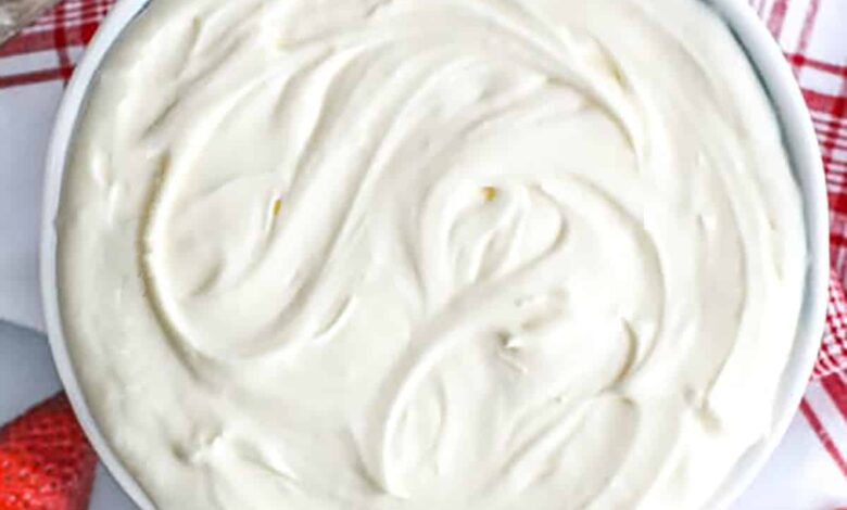 Creamy Cucumber Salad in a mixing bowl being stirred with a spoon