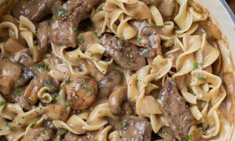 beef stroganoff with egg noodles in a white dutch oven