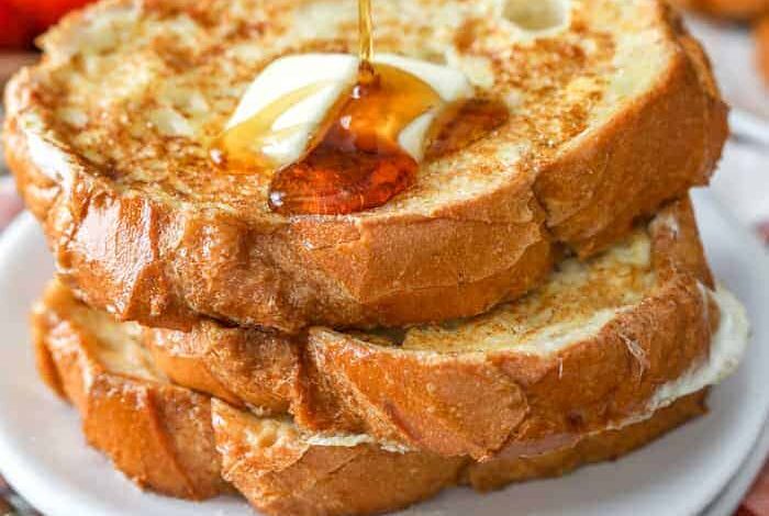 Pouring syrup over a stack of french toast
