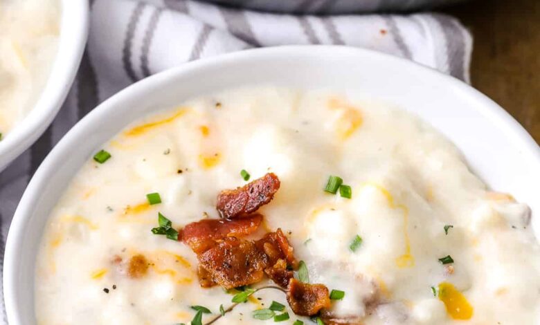 A bowl of creamy potato soup garnished with cheese and bacon