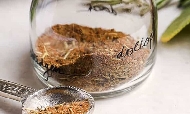 close up of turkey seasoning in a glass jar with a measuring spoon