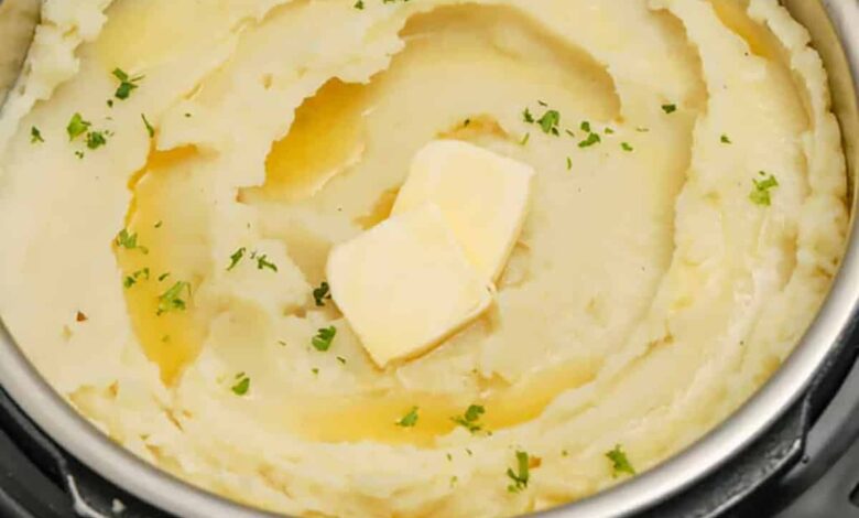 mashed potatoes in an Instant Pot with pats of butter and parsley as garnish