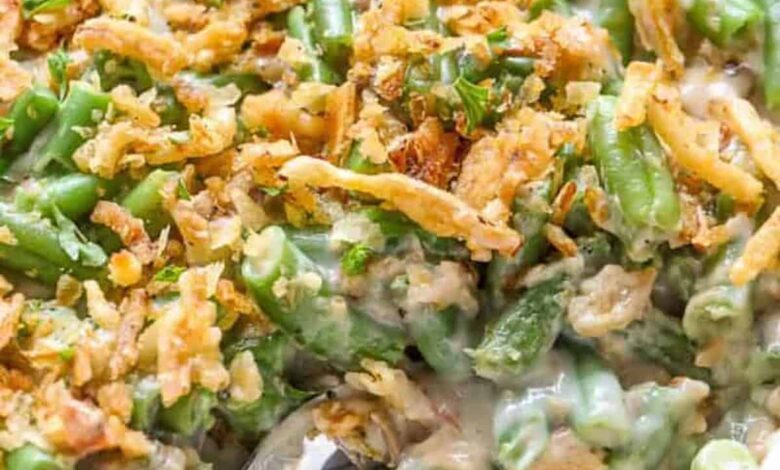 green bean casserole in a white dish with a spoon
