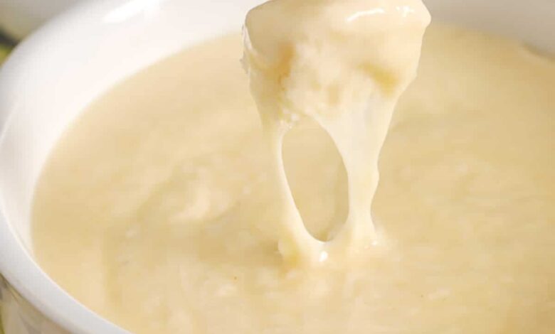 dipping bread in Easy Cheese Fondue Recipe