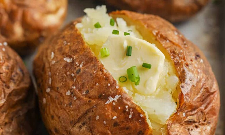 potatoes cooked on a sheet pan with garnish to show How to Make Baked Potatoes